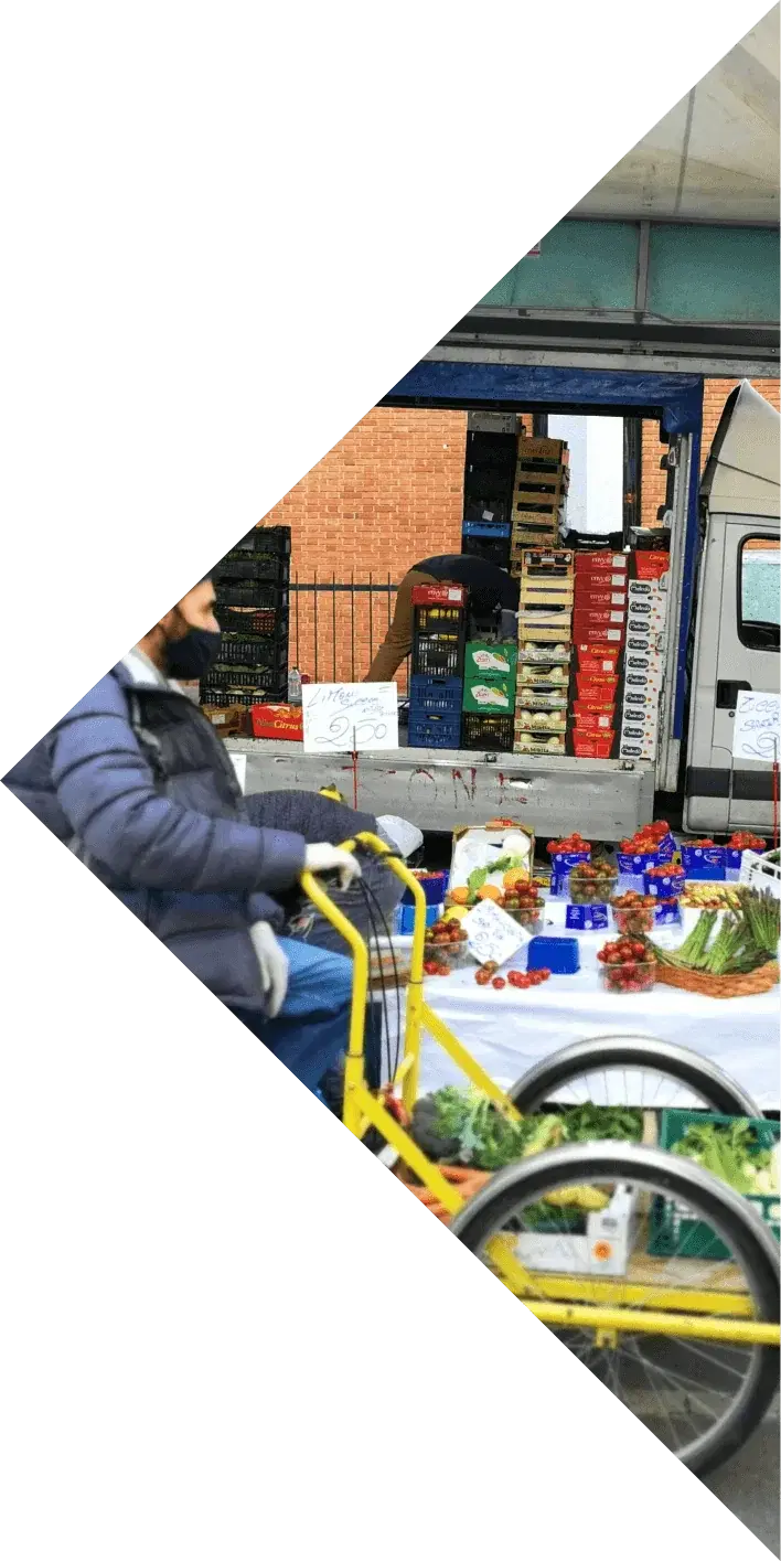 Market stall with crates of fruit and vegetables and a cargo bike