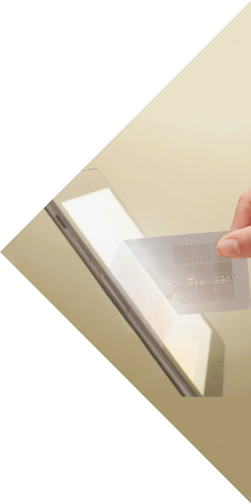 Hand holding a payment card next to a tablet